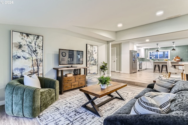 living room featuring vaulted ceiling and light hardwood / wood-style flooring