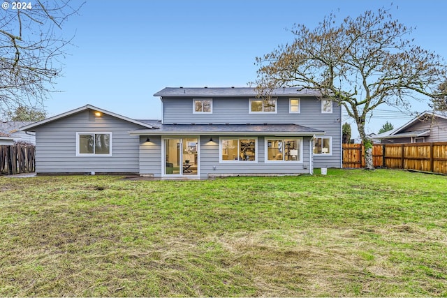 rear view of property featuring a lawn