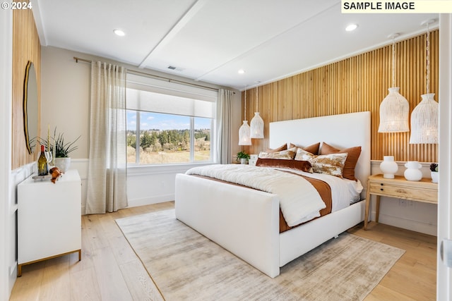 bedroom featuring wooden walls and light hardwood / wood-style flooring