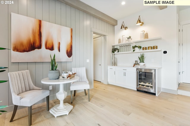 bar featuring white cabinetry, beverage cooler, and light wood-type flooring