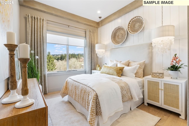 bedroom with an inviting chandelier and light hardwood / wood-style floors