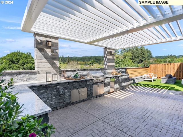 view of patio with exterior kitchen, area for grilling, and a pergola