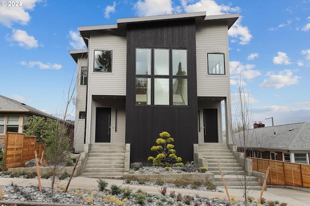 modern home with fence and entry steps