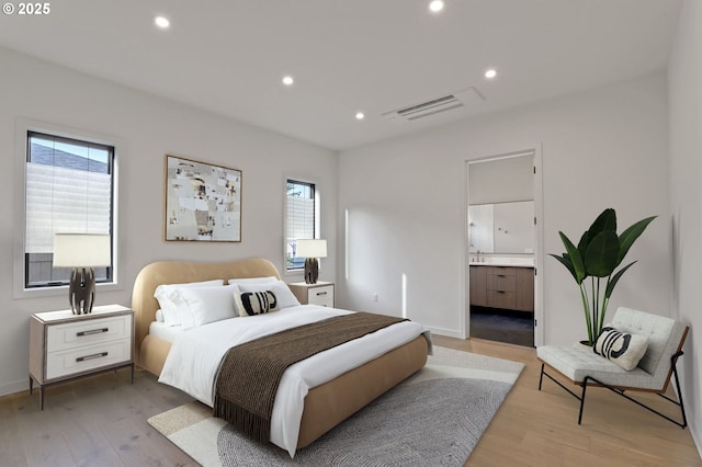 bedroom with multiple windows, visible vents, and light wood-type flooring