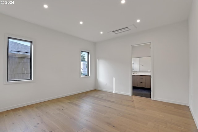 unfurnished room with light wood finished floors, baseboards, visible vents, and recessed lighting
