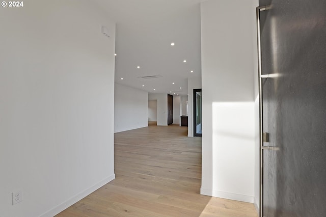hall with light wood-style flooring, baseboards, and recessed lighting