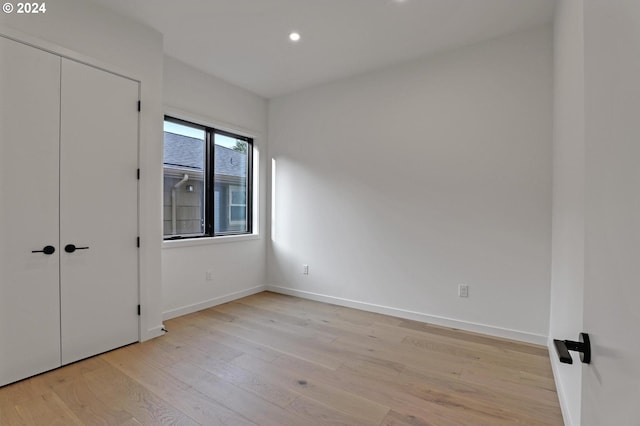 unfurnished bedroom featuring light hardwood / wood-style floors and a closet