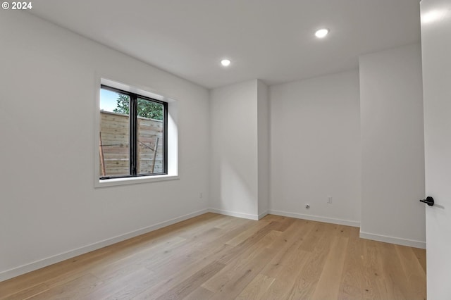 unfurnished room featuring recessed lighting, light wood finished floors, and baseboards