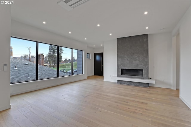 unfurnished living room featuring a fireplace and light hardwood / wood-style flooring