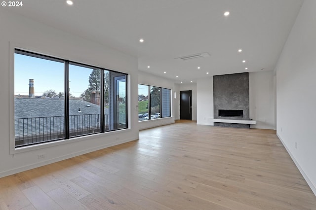 unfurnished living room featuring a fireplace and light hardwood / wood-style floors