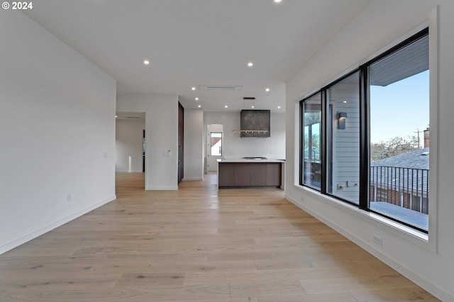 unfurnished living room featuring recessed lighting, baseboards, and light wood-type flooring