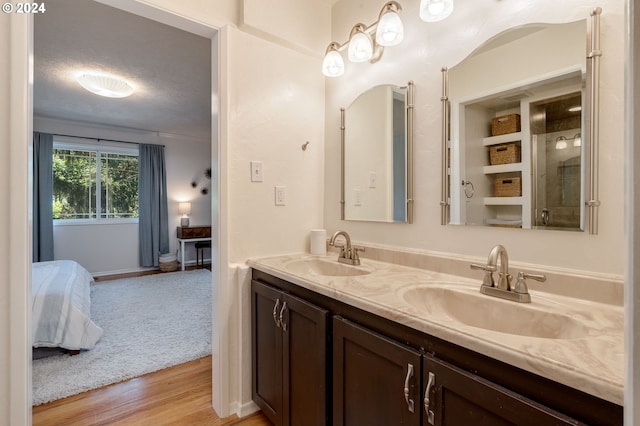 bathroom with hardwood / wood-style floors, vanity, and a textured ceiling