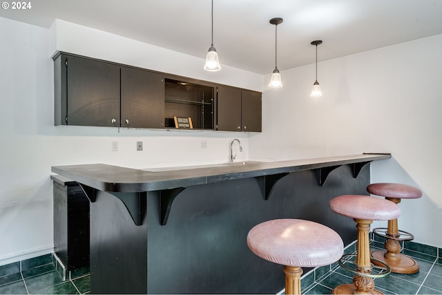 bar featuring dark tile patterned flooring, sink, and pendant lighting