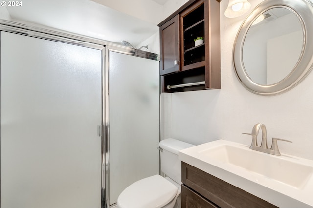 bathroom with toilet, walk in shower, and vanity