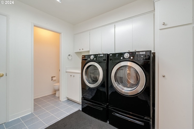 laundry room with washing machine and dryer and cabinets