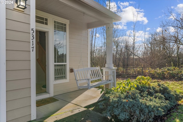 view of exterior entry featuring covered porch