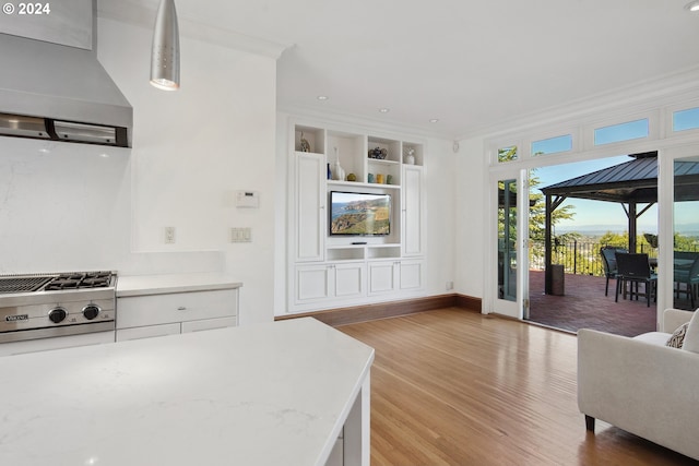 2868 NW Cumberland Rd, Portland, OR 97210 - kitchen featuring wall chimney range hood, light wood finished floors, open floor plan, light countertops, and crown molding