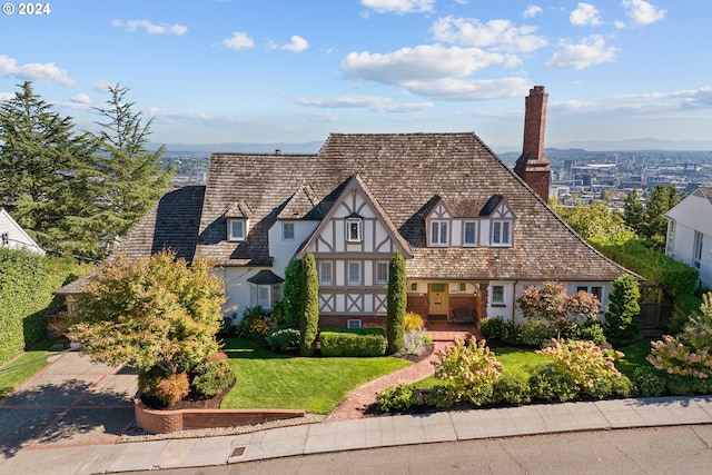 2868 NW Cumberland Rd, Portland, OR 97210 - tudor-style house with a chimney, a front lawn, and stucco siding