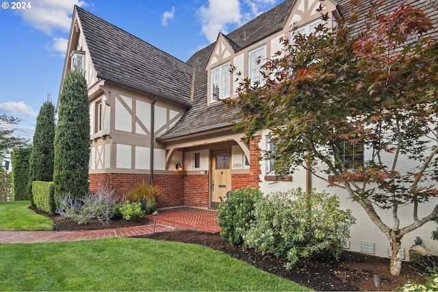2868 NW Cumberland Rd, Portland, OR 97210 - tudor-style house featuring stucco siding, brick siding, and a front lawn