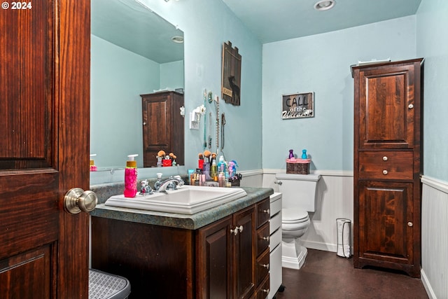 bathroom featuring vanity, toilet, and wainscoting