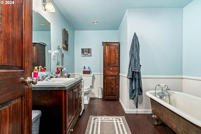 bathroom featuring a wainscoted wall, toilet, vanity, and a freestanding bath