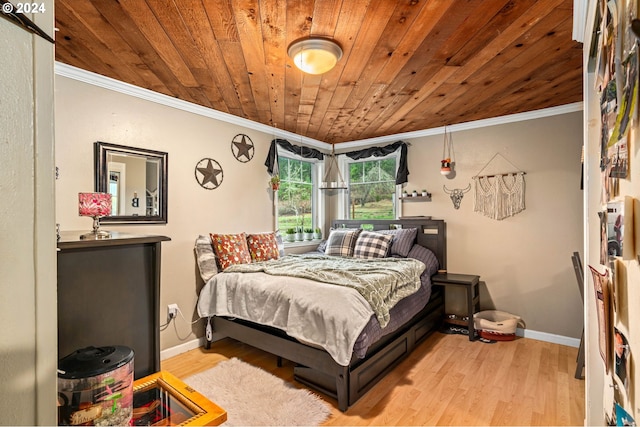 bedroom with wooden ceiling, crown molding, baseboards, and wood finished floors