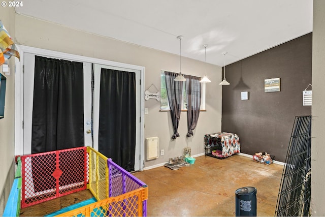 playroom with baseboards and concrete floors