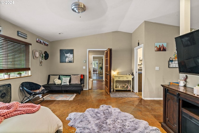 interior space featuring concrete floors, baseboards, and vaulted ceiling