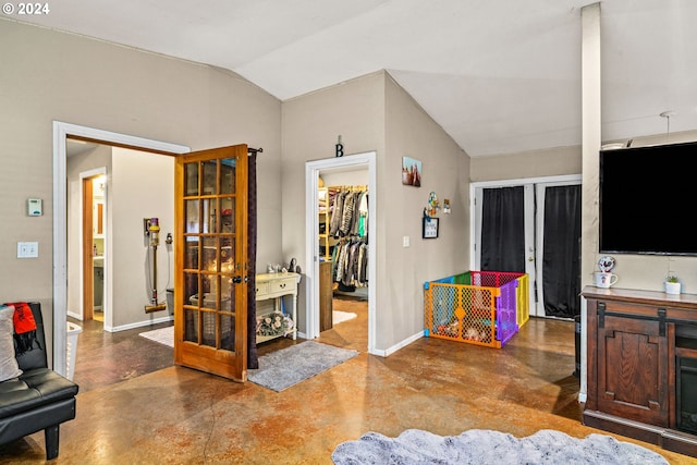 interior space with concrete flooring, vaulted ceiling, and french doors