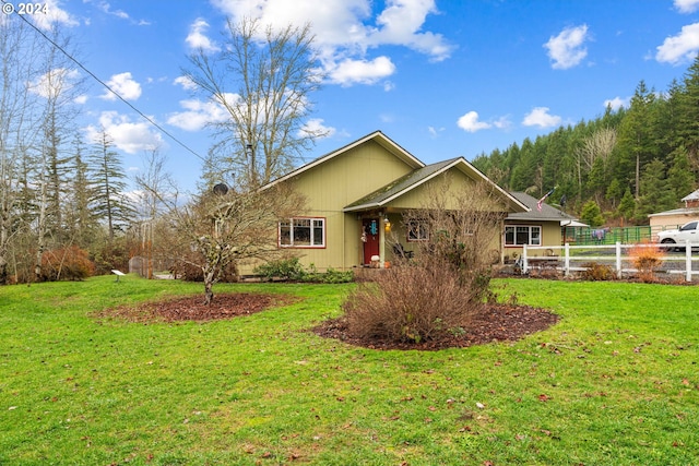 ranch-style home with a front yard and fence