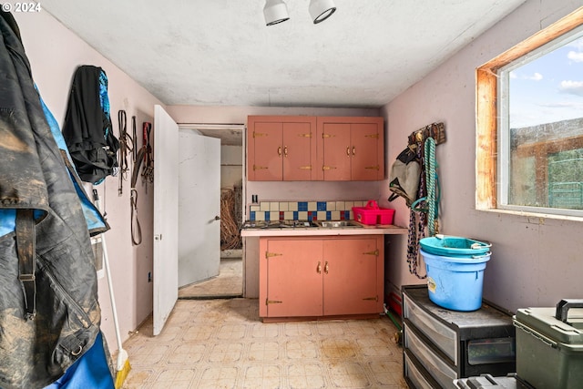 kitchen featuring tasteful backsplash, light floors, and light countertops