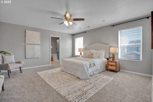 carpeted bedroom featuring ceiling fan, connected bathroom, and a textured ceiling