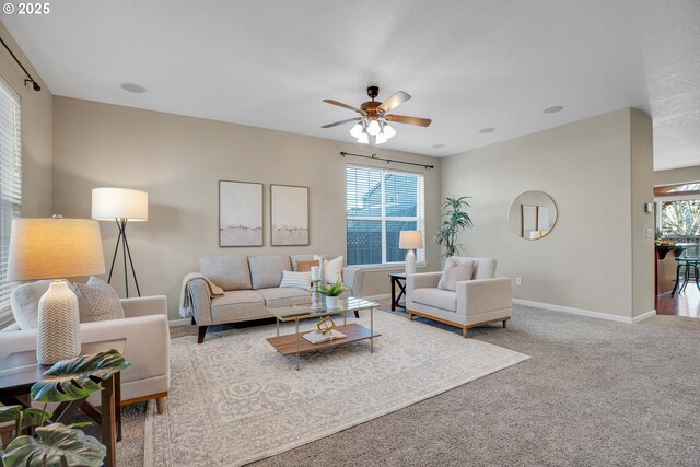 living room featuring light colored carpet, ceiling fan, and a textured ceiling