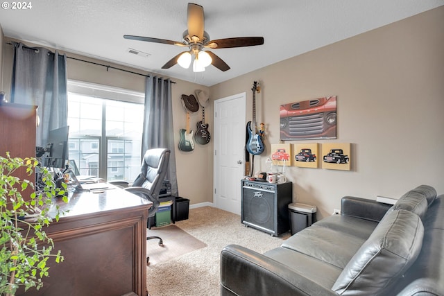 carpeted office space featuring ceiling fan and a textured ceiling