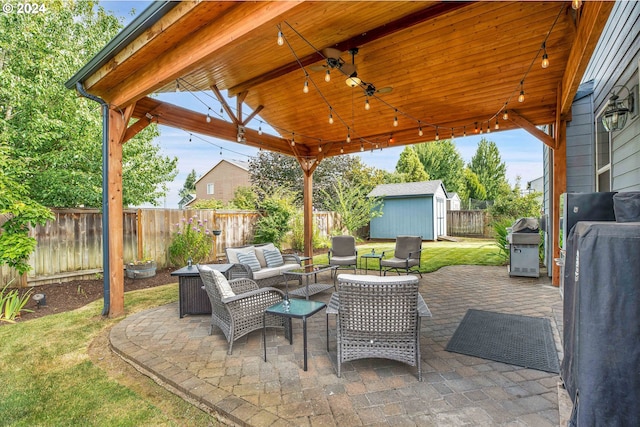 view of patio / terrace featuring a grill, an outdoor hangout area, ceiling fan, a shed, and a gazebo