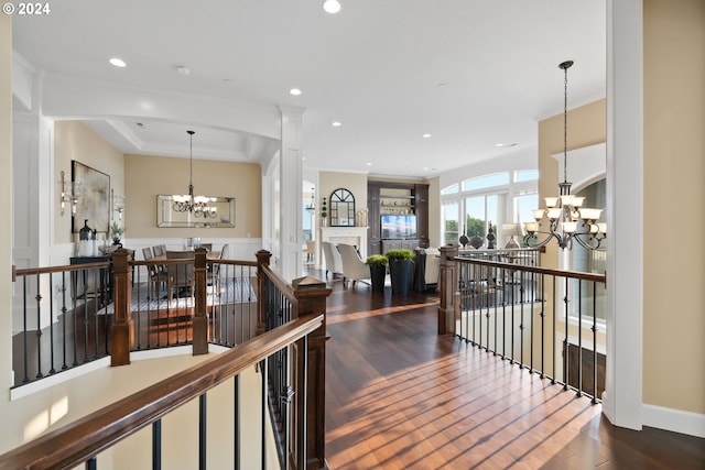 hall with dark hardwood / wood-style flooring and an inviting chandelier