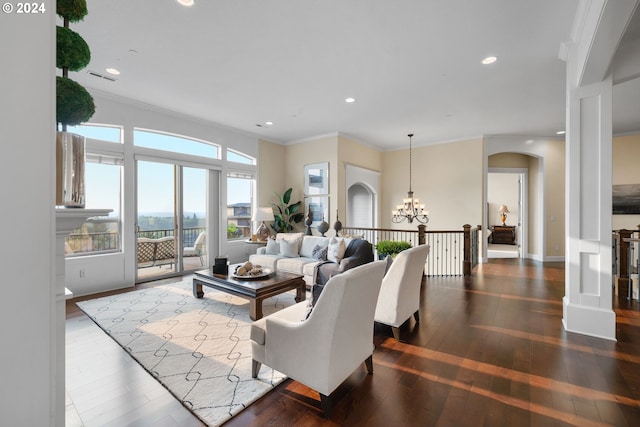 living room with dark wood-type flooring, a chandelier, and ornamental molding