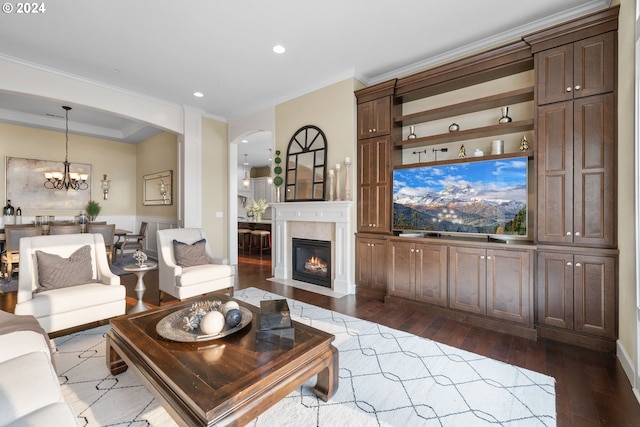 living room with crown molding, dark hardwood / wood-style flooring, and a notable chandelier