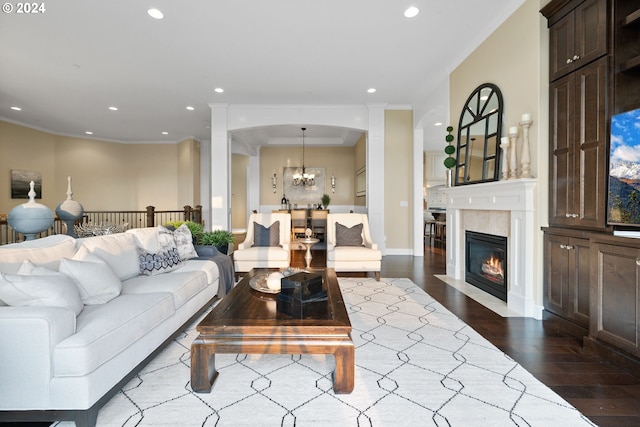 living room featuring ornamental molding, an inviting chandelier, and dark hardwood / wood-style floors