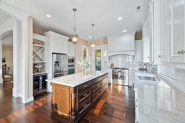 kitchen with white cabinets, a center island, stainless steel appliances, sink, and wine cooler