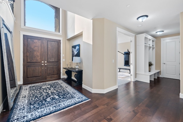 entryway with dark wood-type flooring and a high ceiling