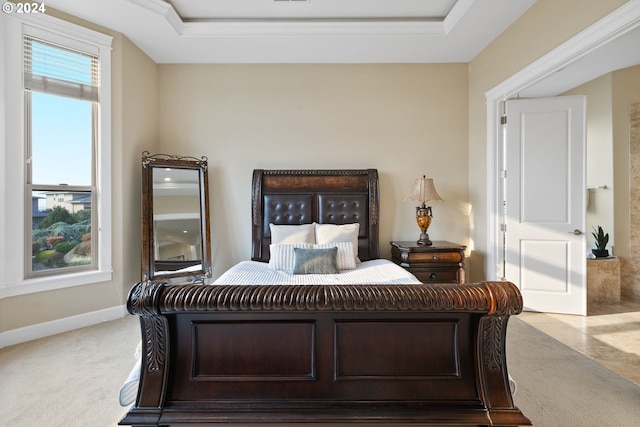 carpeted bedroom featuring ornamental molding and a raised ceiling