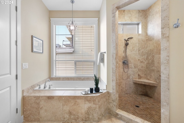 bathroom with shower with separate bathtub and an inviting chandelier