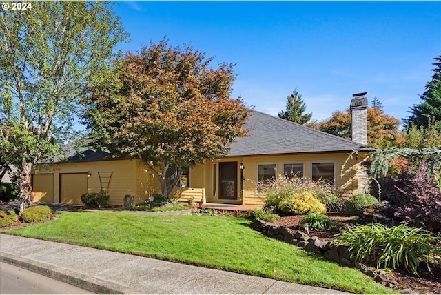 view of front of home featuring a front yard and a garage