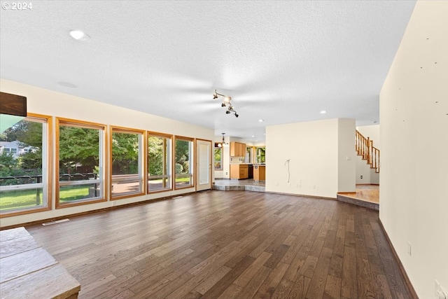 unfurnished living room with dark hardwood / wood-style floors and a textured ceiling