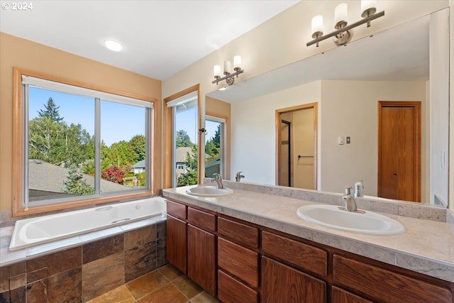 bathroom featuring tiled tub and vanity