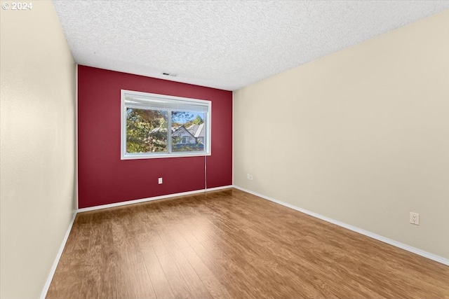 unfurnished room featuring hardwood / wood-style floors and a textured ceiling