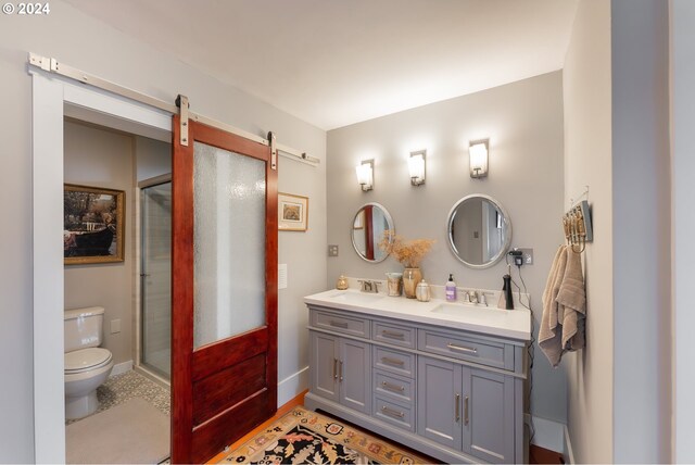 bathroom with vanity, a shower with shower door, and toilet