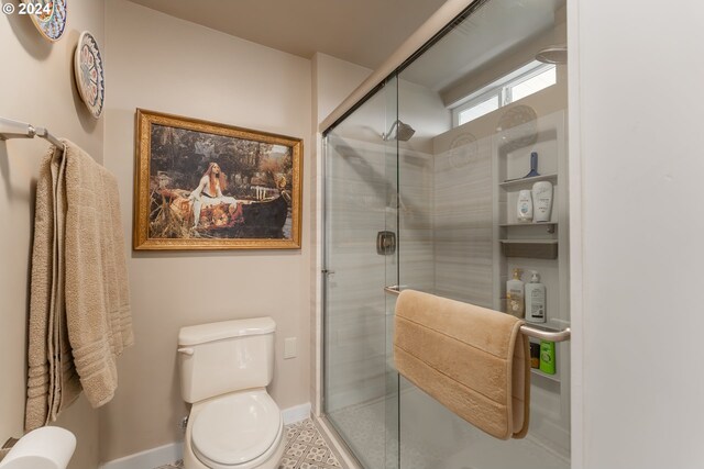 bathroom with toilet and a shower with door