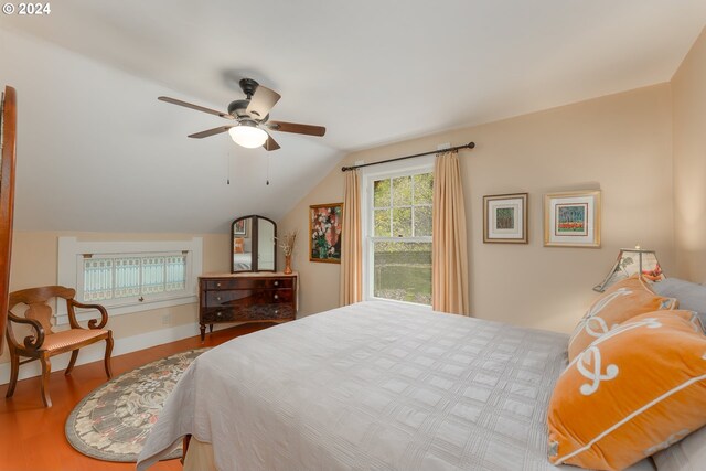 bedroom with ceiling fan, wood-type flooring, and lofted ceiling